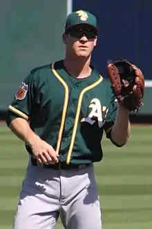 A baseball player in dark green and gray