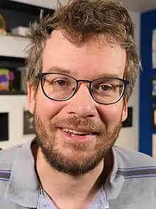 John Green in a vlog, smiling to camera