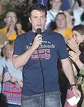 Ben Affleck speaking into a microphone while wearing a Kerry/Edwards campaign tshirt