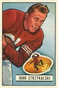 A football trading card showing Strzykalski running with a football with his name printed on the bottom