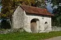 A gate with a sundial on the churchyard wall