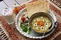 Kashk-e Bademjan is probably the most popular appetizer in Iran. It is even eaten as a main course in some parts of the country. In this picture you can see Iranian drink "Doogh" next to the dish which is made of yogurt.