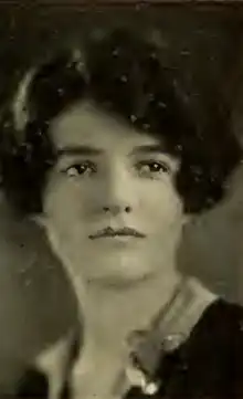 A young white woman with dark wavy hair cut in a bob with a sidepart