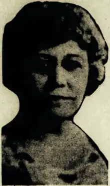 B&W portrait photo of a middle-aged woman wearing a scooped-neck patterned blouse