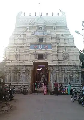 A large, multi-level building with a central doorway and an ornamental roof.