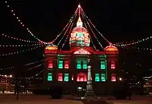 Building with strings of colored lights running from top of cupola to sides of square