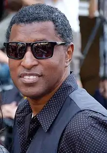 Image of Babyface wearing polka-dot shirt, sunglasses and smiling