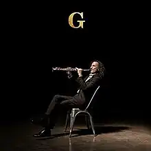 Kenny G seated, playing saxophone