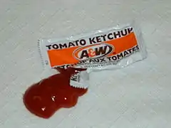 A packet of ketchup, opened with the contents squeezed out