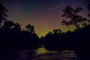 Shooting star seen through an aurora, taken over the Kewaunee River.