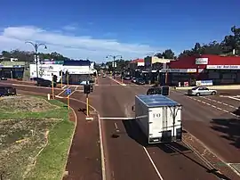 A photographic long shot of commercial buildings lining a road