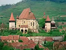 rural village landscape with old church steeple in the mid-distance and terraced hills in the background