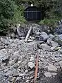 The mine viewed from the foot of the mill. A half-buried piece of rail is still extant.