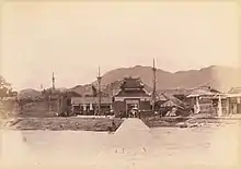 The front entrance of a fort with mountains in the background.