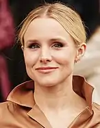 Young Caucasian woman wearing her blonde hair pulled back behind her head. She is smiling slightly while looking into the camera.