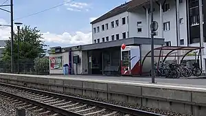 Flat-roofed waiting area on platform next to railway line