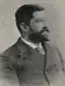 A black-and-white photograph of a man in a suit with a tie