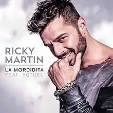 A portrait of Ricky Martin with his hand on his mouth