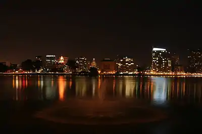 The skyline of a city seen at night from across a lake