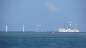 Wind turbines of the Mampuri and Madurankuliya wind farms next to the Lakvijaya Power Station, as seen from the Puttalam Lagoon.