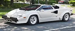 A white sports car parked on the side of the road.