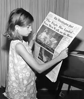 Image 38A girl reading a 21 July 1969 copy of The Washington Post reporting on the Apollo 11 Moon landing (from Newspaper)