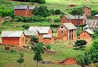 Two-story rectangular brick building with peaked roof and no balcony or supporting columns