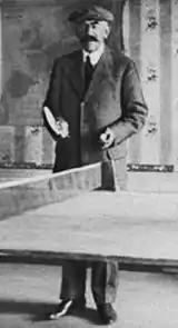 Lenglen's father standing behind a table tennis table