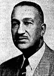 Black and white photograph portrait of a man in a suit, white dress shirt, and necktie.