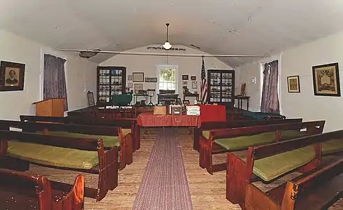 Interior of the People's Hall, note the motto "Let Truth and Error Grapple" on the arch above the stage