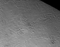 Close up of the volcanic province of Leviathan Patera, the caldera in the center of the image. Several pit chains extend radially from the caldera to the right of the image, while the smaller of the two cryolava lakes is seen to the upper left. Just off-screen to the lower left is a fault zone aligned radially with the caldera, indicating a close connection between the tectonics and volcanology of this geologic unit.