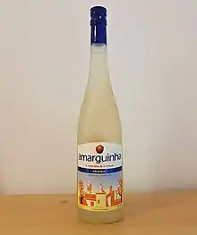 A bottle of Amarguinha Original on a wooden table, against a white background.