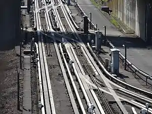 Lille Metro line 1 near Quatre Cantons Workshop, the absence of conventional rail for guidance at junctions is compensated by a central stub guide rail.