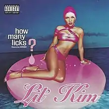 An image of a woman wearing a pink swimsuit and swimming cap while sitting on a pink circle. The names of the single and the artist are superimposed over the image.