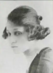 A young Black woman with light skin and hair drawn back across crown and dressed into a curly bob