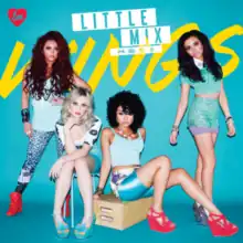 Little Mix pose in front of a blue background with "Wings" written in yellow.