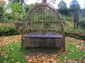 A living willow seat on the lawn outside the house.