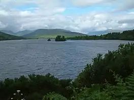 A lake surrounded by trees and hills