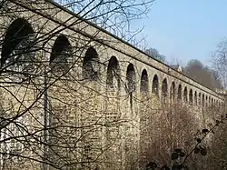 A stone viaduct viewed at an angle looking up