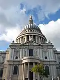 A white building with columns and a grey dome.