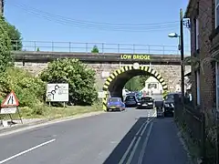 Large "low bridge" sign with hazard marking on the bridge