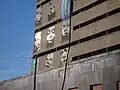 some lower west wall faces of caseros prison with Huracan bandera. July, 2006.