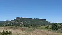 Lower Table Rock from across a field. Similar to Upper Table Rock, it rises steeply to its very flat top.