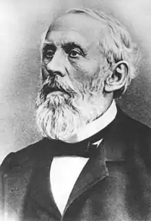 Profile photograph of Ludwig Tobler, with a beard, suit, and bow tie, looking longingly off to the side