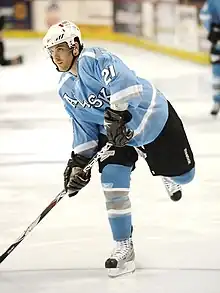 Hockey player skating in a powder blue uniform