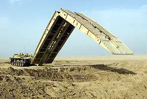 An M60A1 armoured vehicle-launched bridge (AVLB), deploying its scissors-type bridge