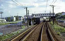 A subway train leaving a surface-level station