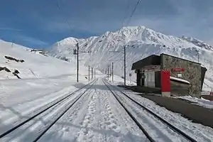 Single-story building next to double-track; snow has fallen