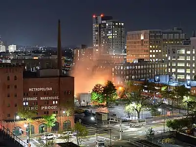 Night time view from the same location. Fog produced by the cooling towers is brightly illuminated by floodlights.