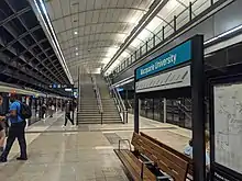 Picture of Macquarie University station. It consists of an underground platform with platform screen doors and a curved roof, similar to Macquarie Park station.